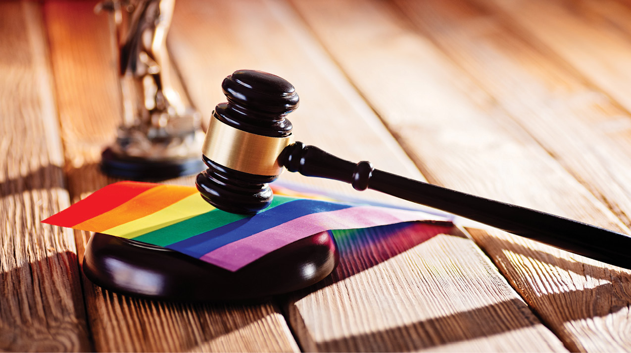 Judge wooden mallet resting on lgbtq rainbow flag