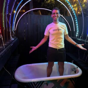 Omar Farias, VMD stands in a bathtub at an event